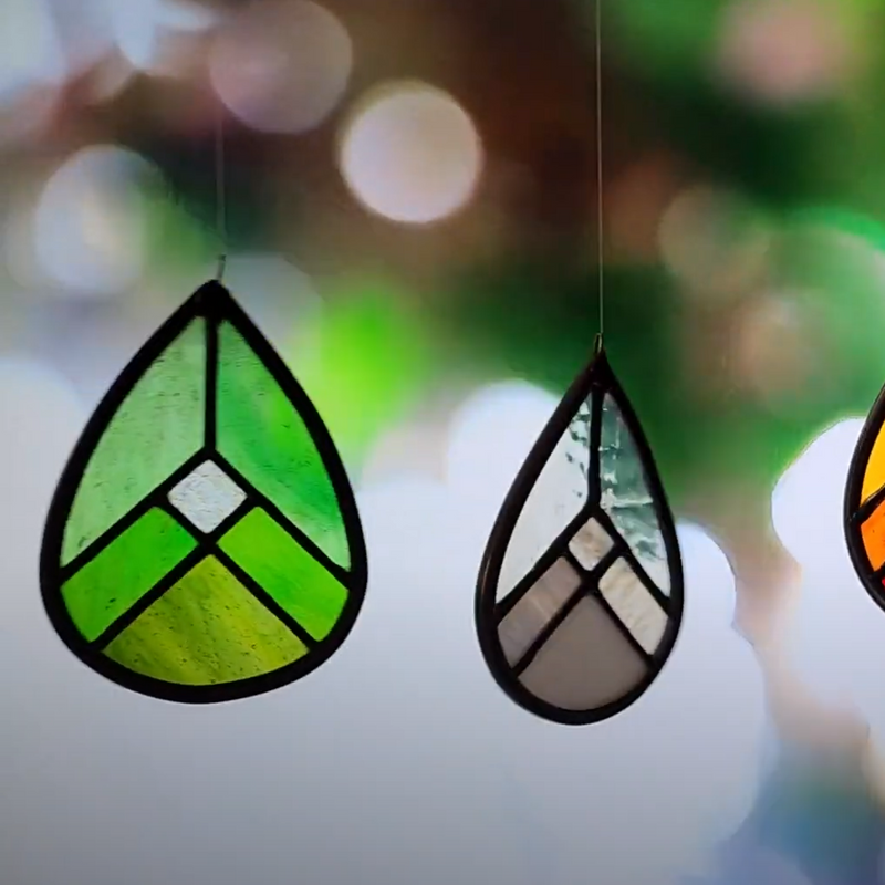 Elemental Drops (Earth, Ari, Fire and Water) Suncatchers shown on a blurred background