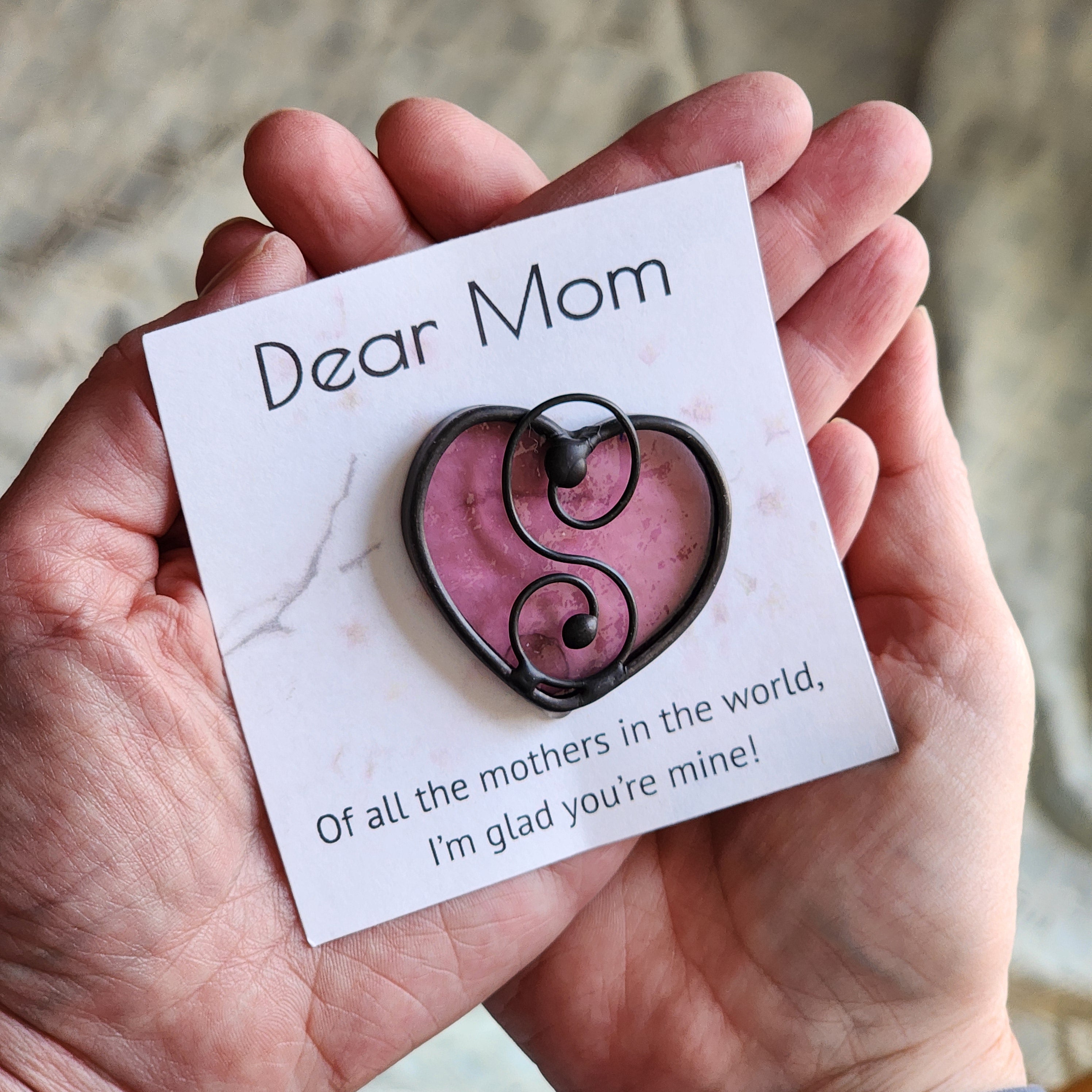 Pink tourmaline colored stained glass suncatcher on a Dear Mom message card, held in outstretched hands