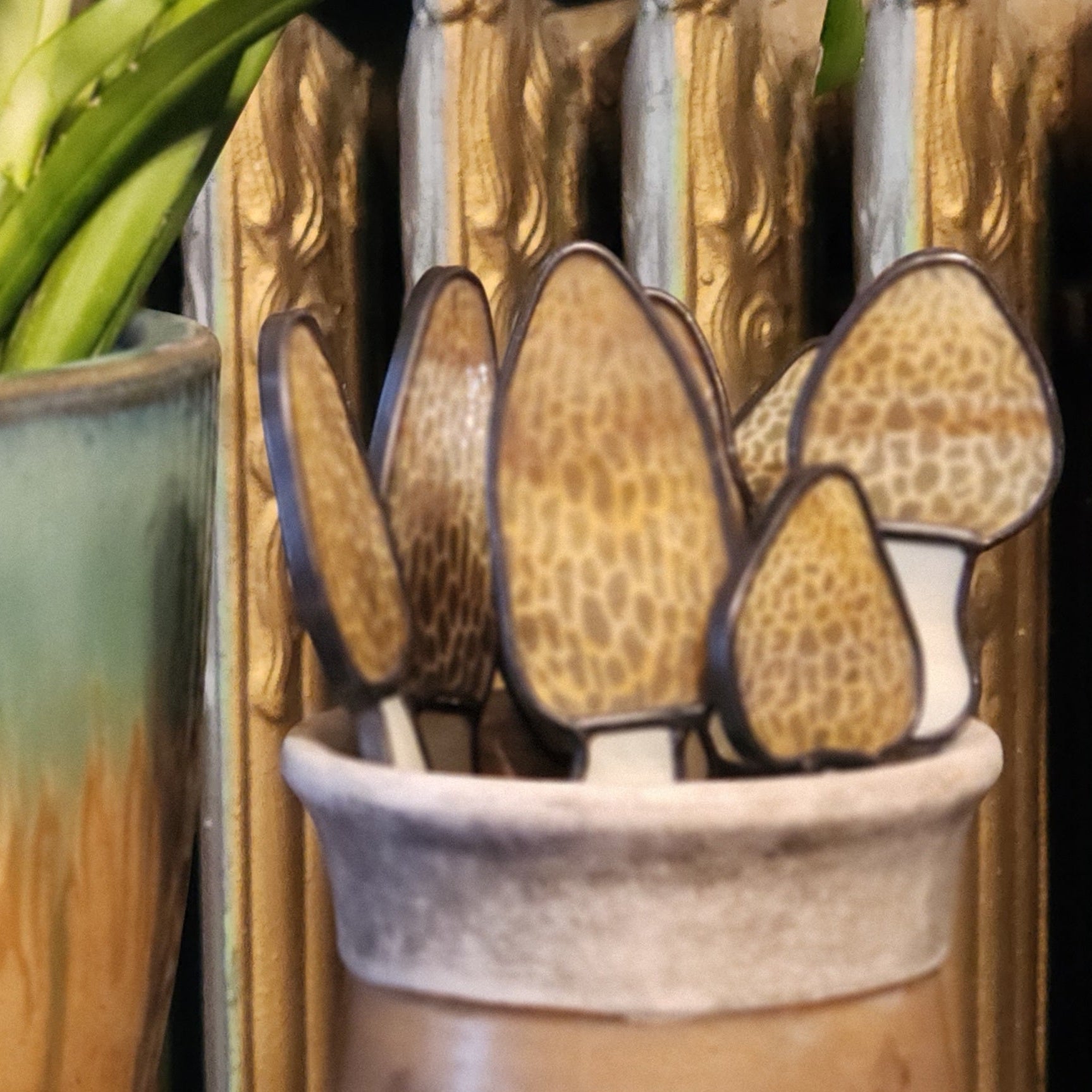 Decorative mushrooms in a pot with a plant in the background