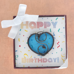 Blue heart-shaped suncatcher in a box with 'Happy Birthday!' text on a brown background