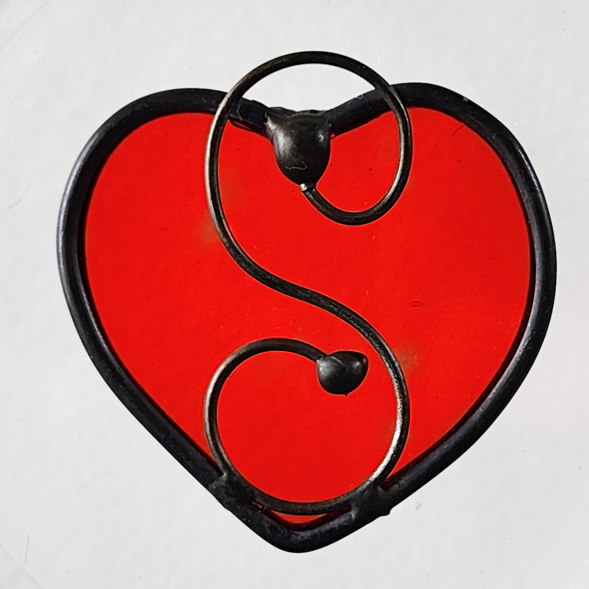 Red heart-shaped stained glass suncatcher charm on a white background