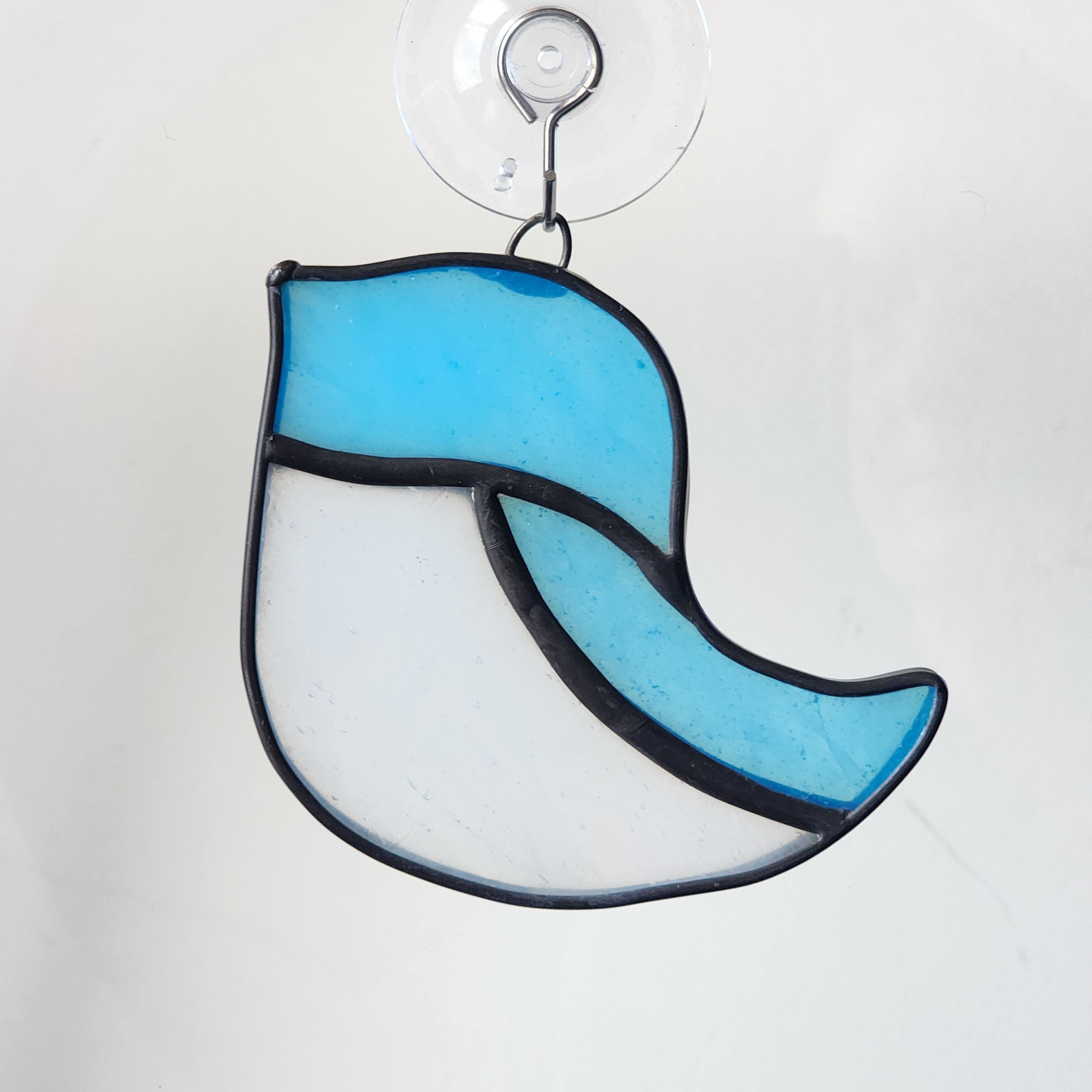 Stained glass suncatcher with blue and white bird design on a white background