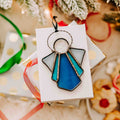 Blue and white stained glass angel suncatcher or ornament on holiday background