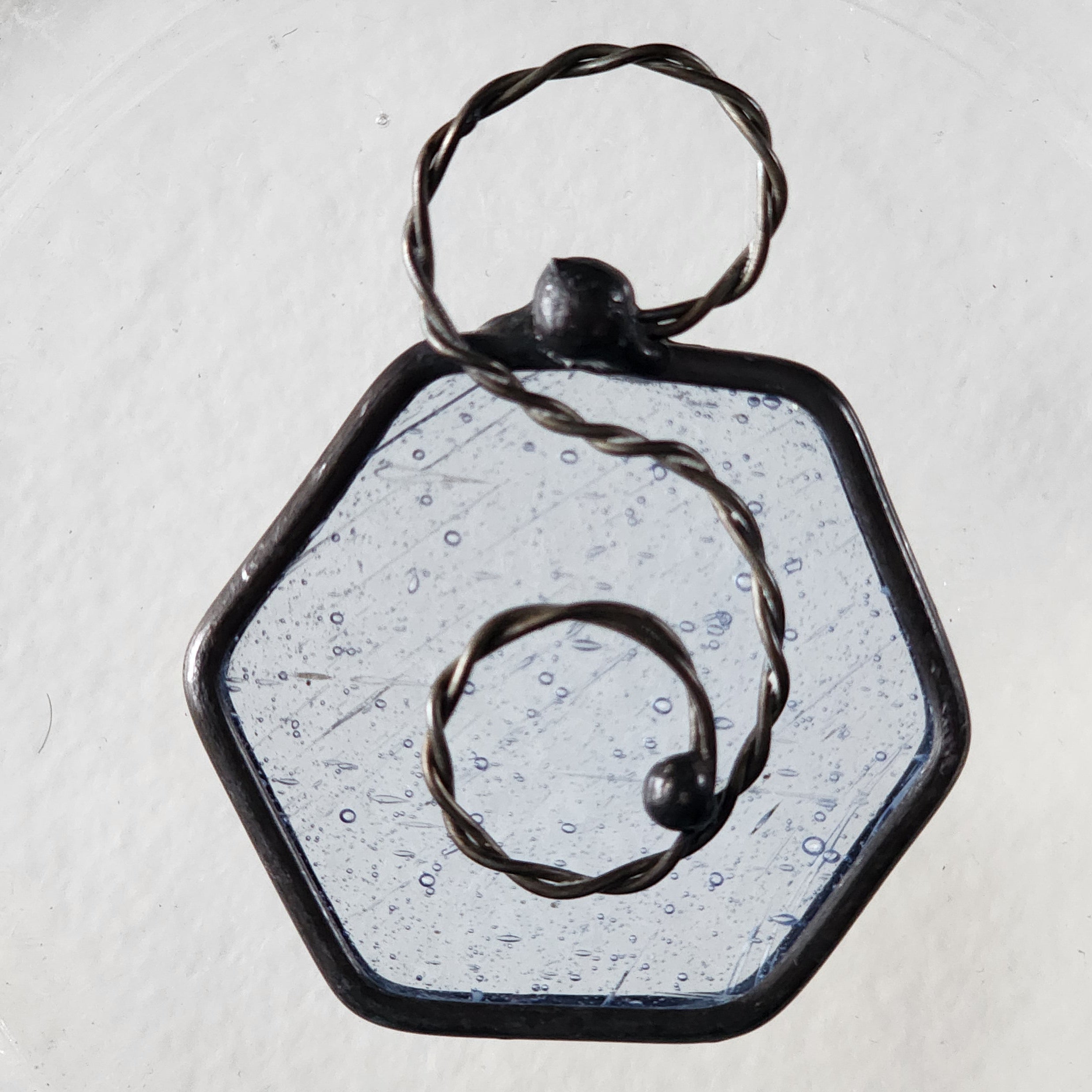 Seedy blue stained glass hexagon charm suncatcher with twisted wire scroll