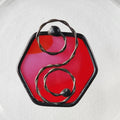 hexagon red suncatcher charm and metal scroll on a white background