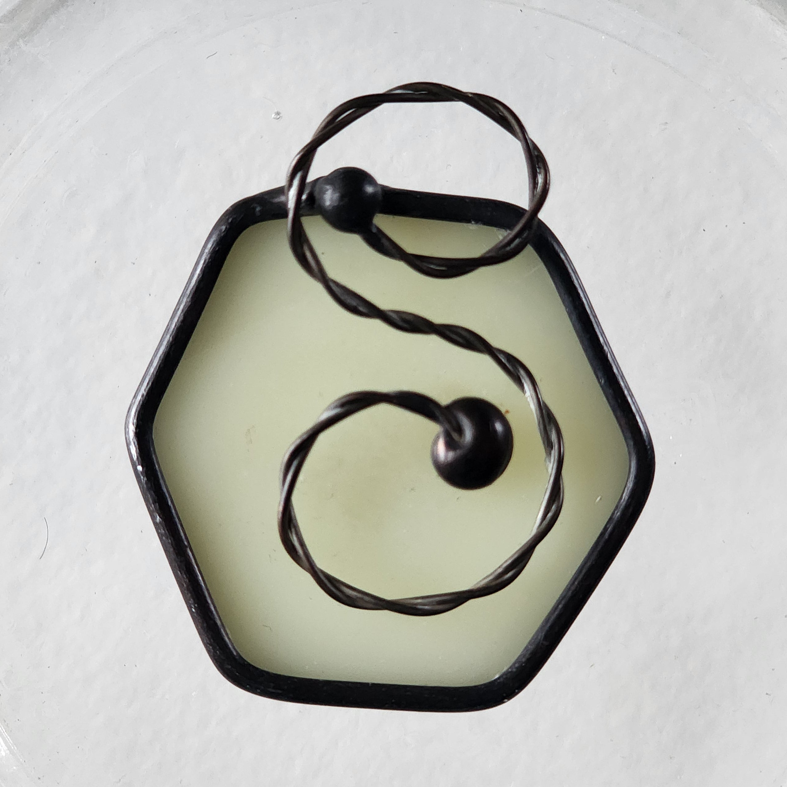Milky white stained glass hexagon charm suncatcher with twisted wire scroll