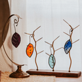 Set of 4 Falling Leaves stained glass suncatchers shown against a white curtain background
