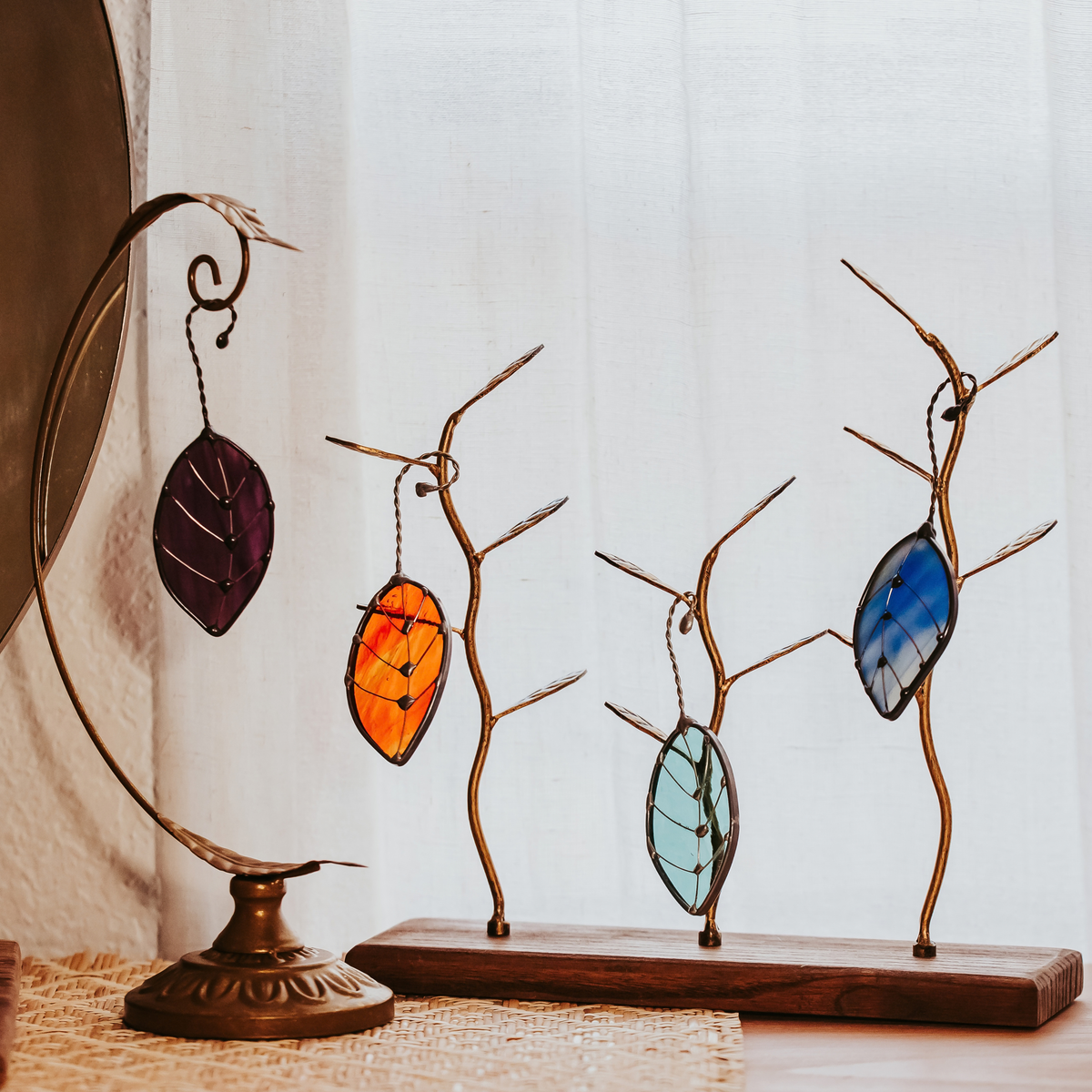 Set of 4 Falling Leaves stained glass suncatchers shown against a white curtain background