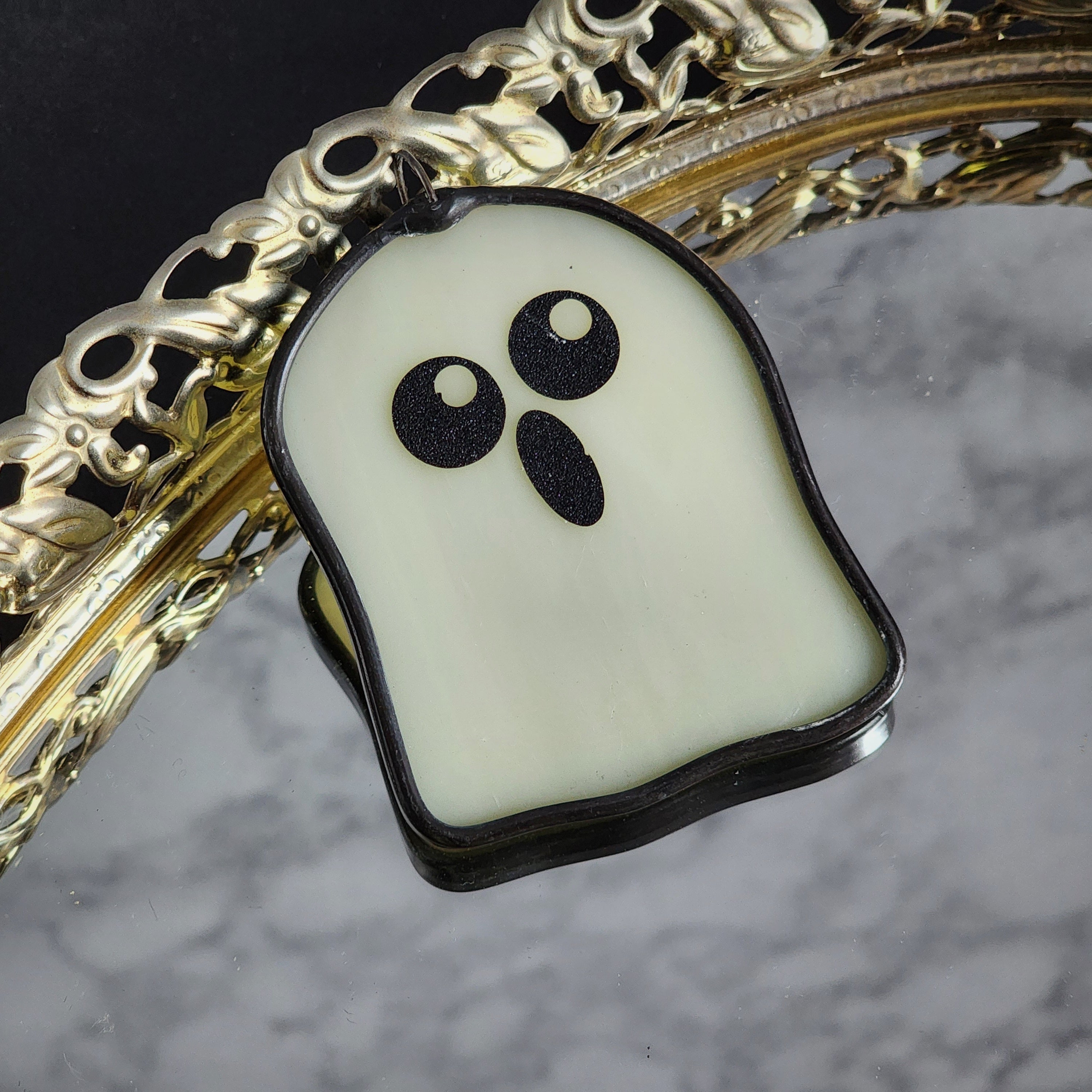 Ghost-shaped suncatcher on a decorative background