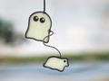Decorative glass ghost walking a ghost dog, hanging on a blurred outdoor background