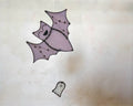 Whimsical purple bat and white ghost stained glass suncatcher on neutral background