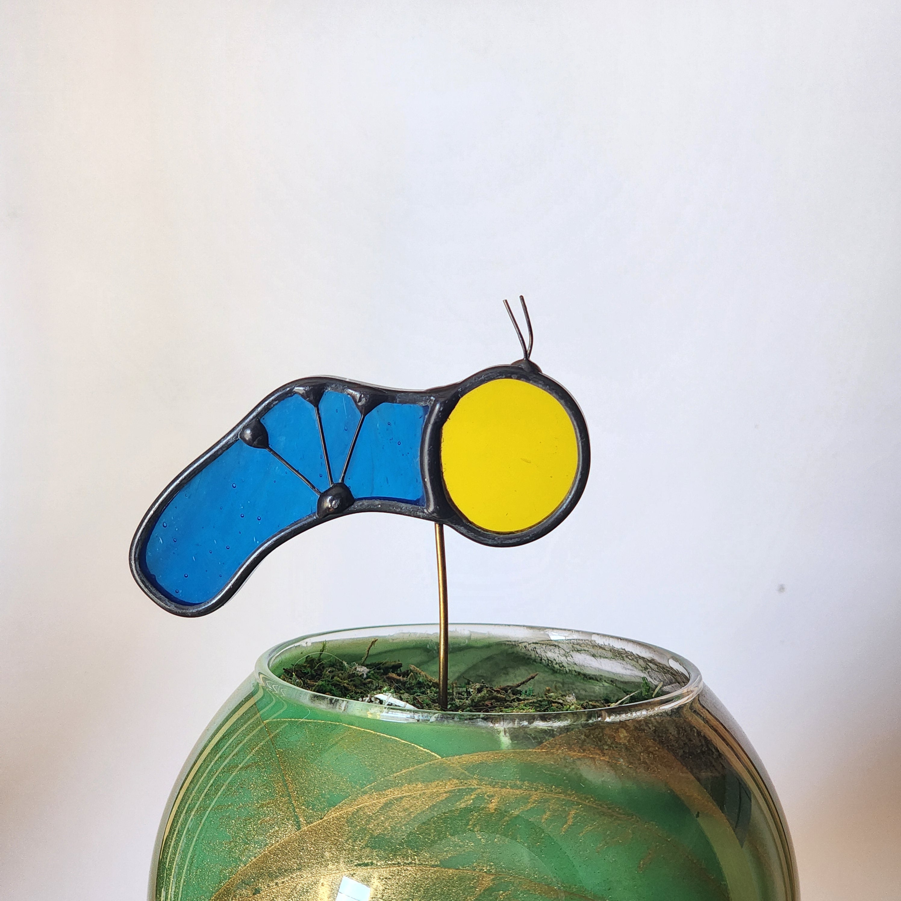 Yellow and Blue caterpillar plant stake on a white background