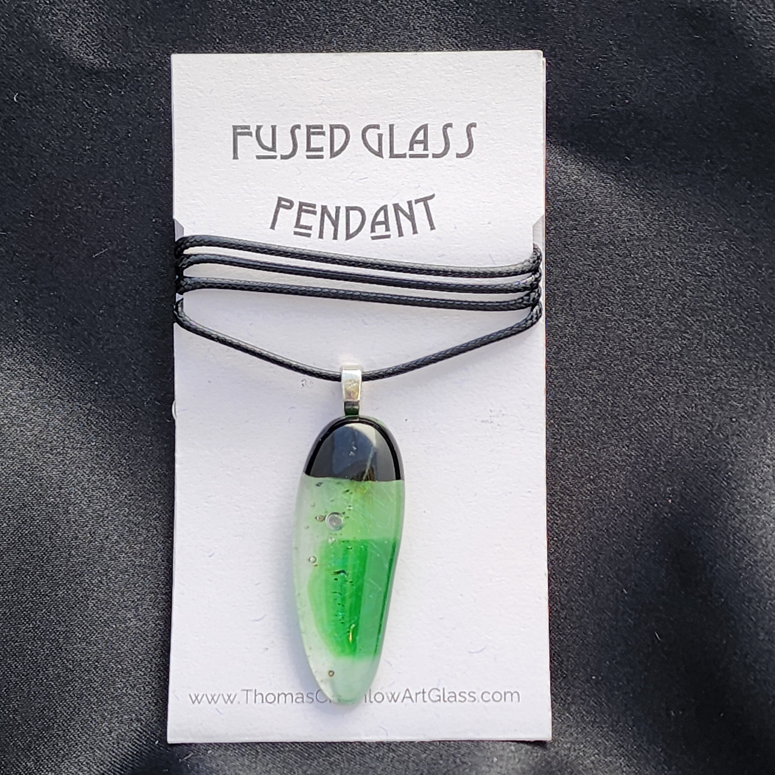 Green fused glass pendant on a card with 'Fused Glass Pendant' text