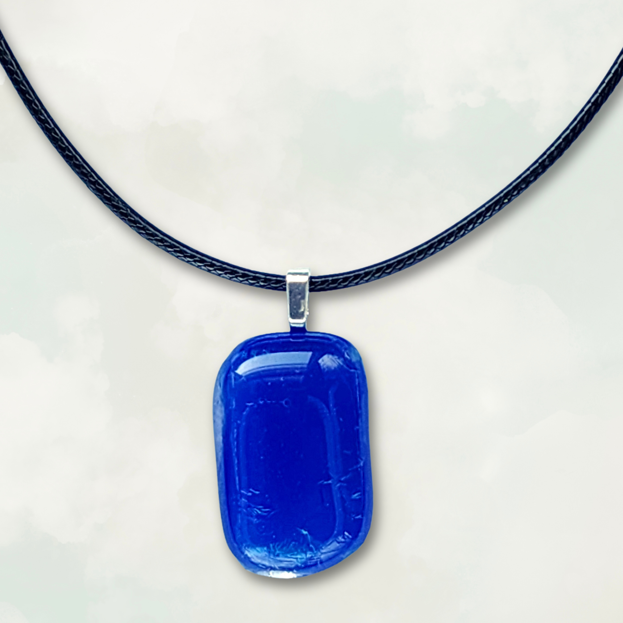 Iridescent blue pendant necklace on a white background