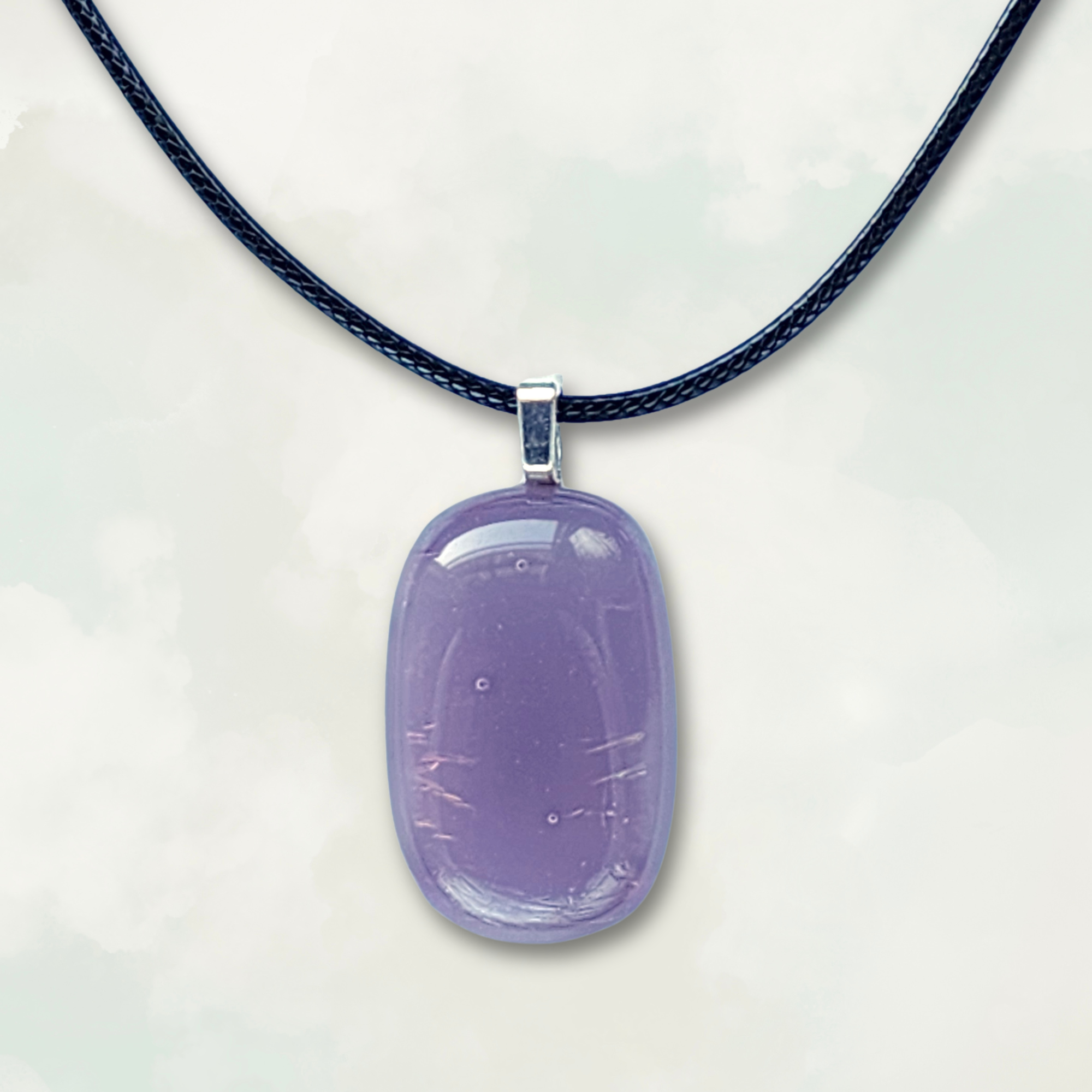 Iridescent purple pendant on a black cord against a white background