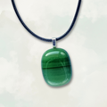 Striped green pendant necklace on a white background