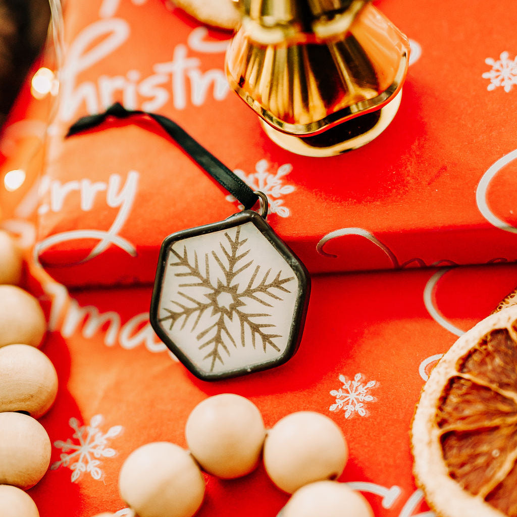 Snowflake hexagon ornament on red Christmas packages