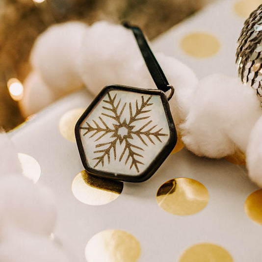 Snowflake hexagon ornament on white and gold Christmas package