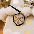 Iridescent snowflake hexagon ornament on Christmas bagckgound