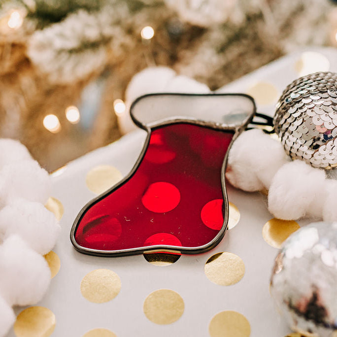 Red and white stained glass christmas stocking on a holiday background