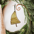 Classic green stained glass Christmas tree ornament with hand twisted metal garland and trunk on a holiday background