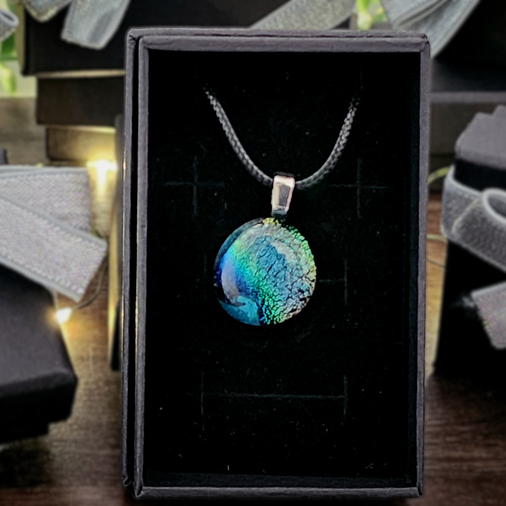 Necklace with a colorful pendant in a black box. 